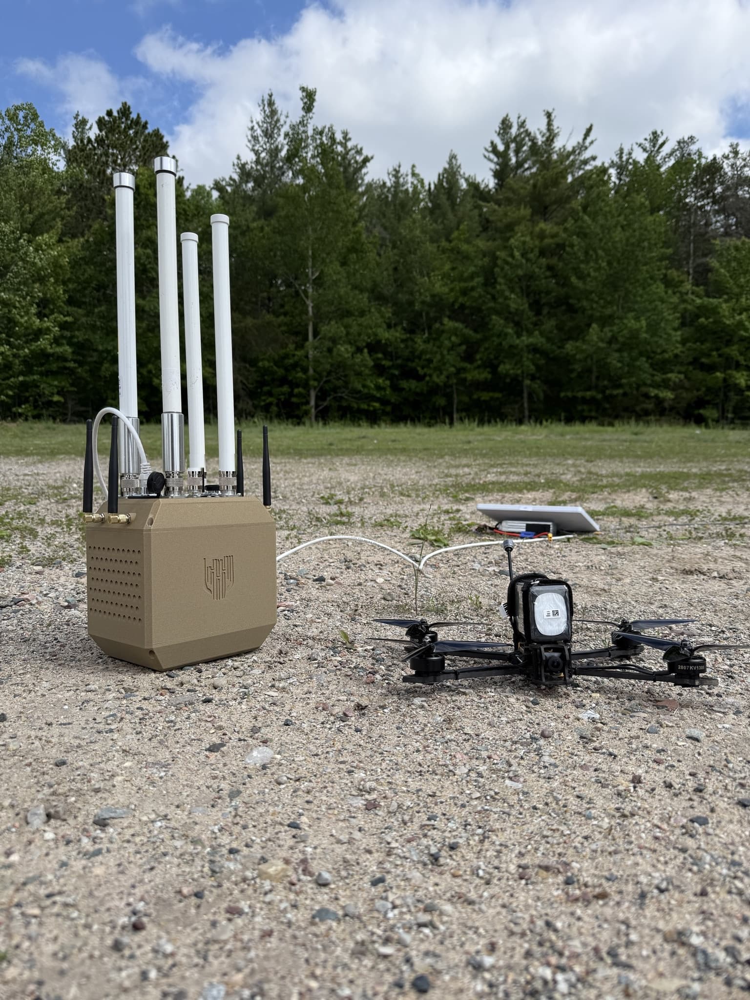 Guardian RF Full Spectrum sensor deployed in the field beside an FPV drone